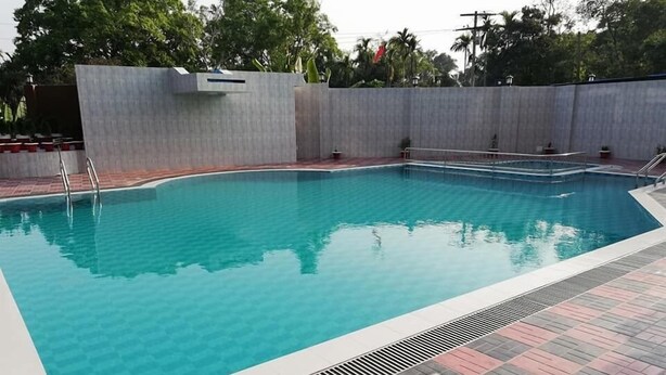 A rectangular swimming pool with a tiled deck surrounding it. - SKD Amar Bari a Luxury Resort (Sreemangal)