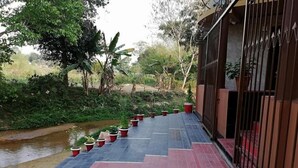 A pathway with potted plants leading to a gated entrance. - SKD Amar Bari a Luxury Resort (Sreemangal)