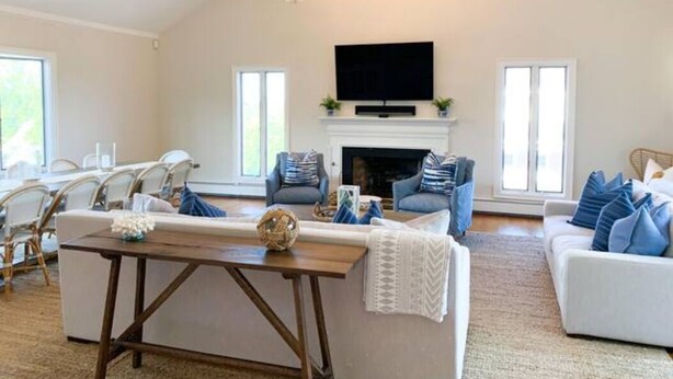 Amplia sala de estar con chimenea, televisor y candelabro.