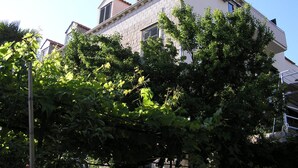 A multi-story building with a stone facade, multiple windows, and a balcony.