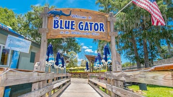 Un muelle de madera que lleva a un cartel que da la bienvenida a visitantes a Blue Gator en el río Withlacoochee.