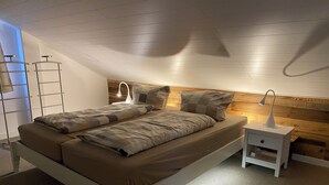 A bedroom with a bed, bedside tables, a lamp, and a wooden headboard. - Large and spacious for max. 6 guests with great views (St. Andreasberg)