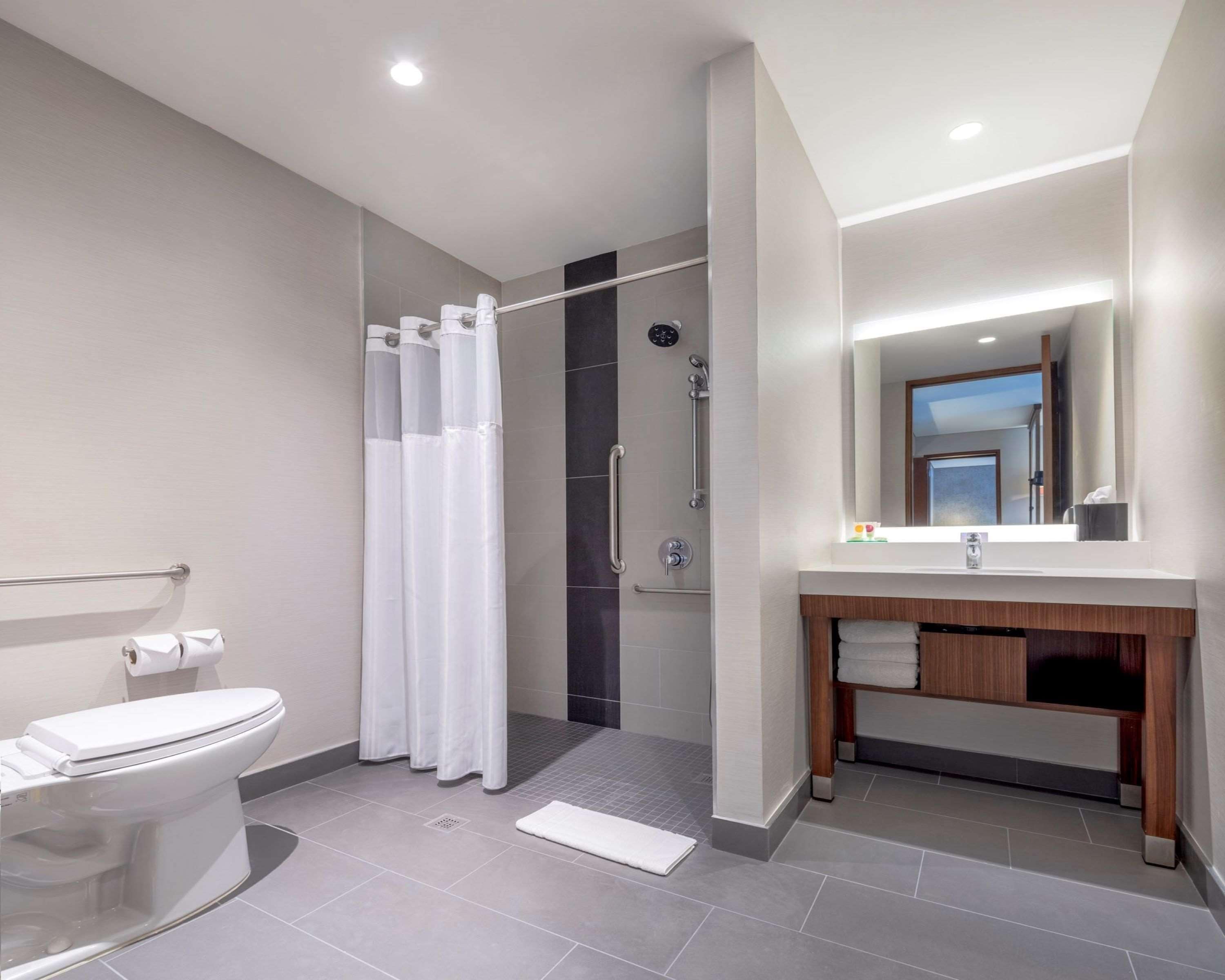Un baño moderno con inodoro, ducha y tocador.