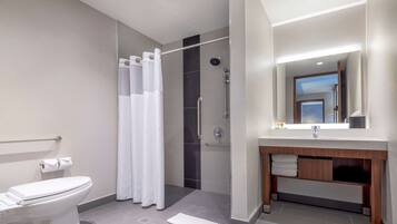 Un baño moderno con inodoro, ducha y tocador.