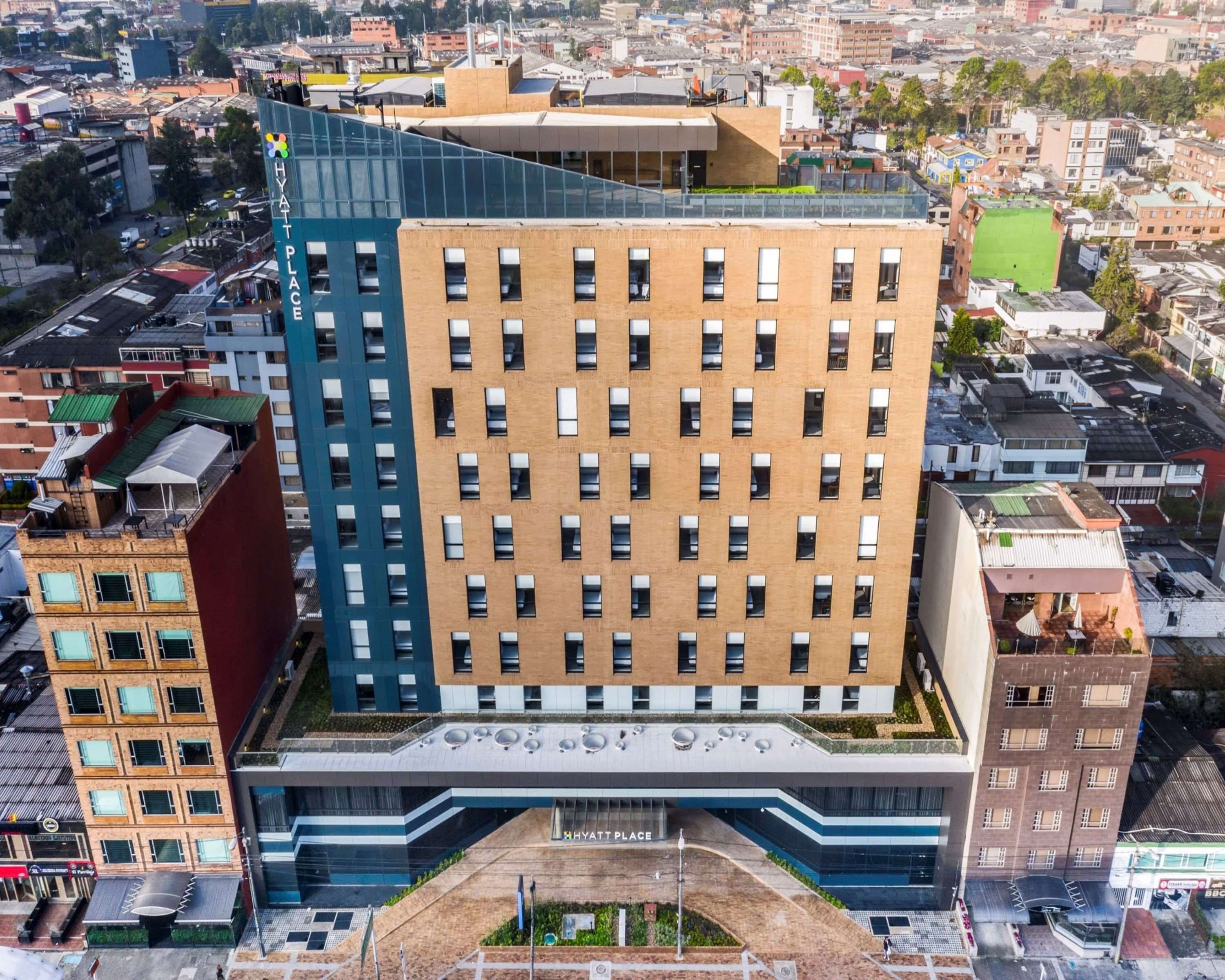A multi-story hotel with a central atrium, large windows, and a flat roof.