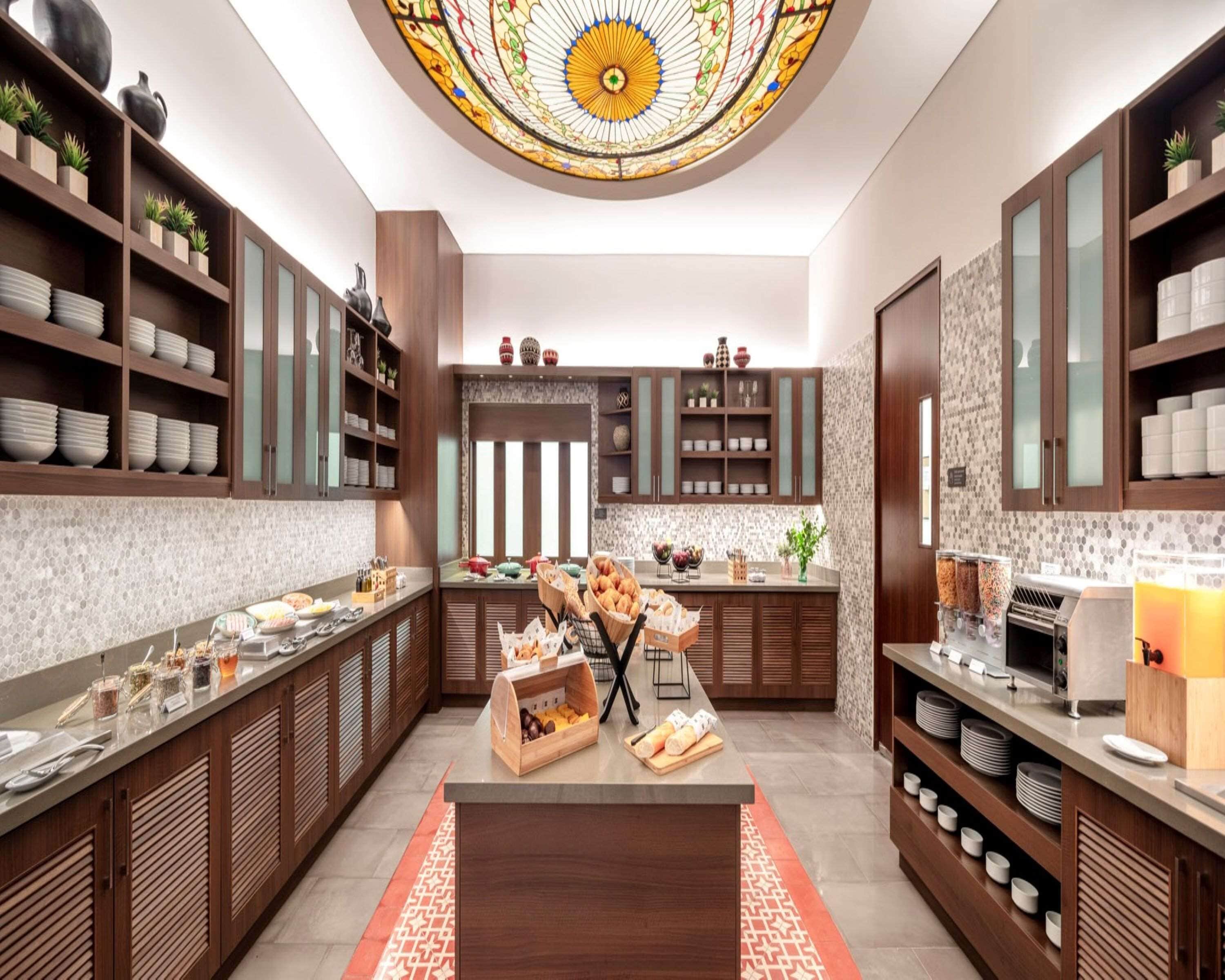 Una cocina moderna con armarios de madera, una isla central y un techo de vitrales.