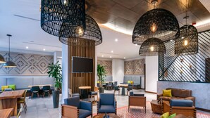 Un espace de détente moderne, doté de sièges, de tables et d’un éclairage décoratif.