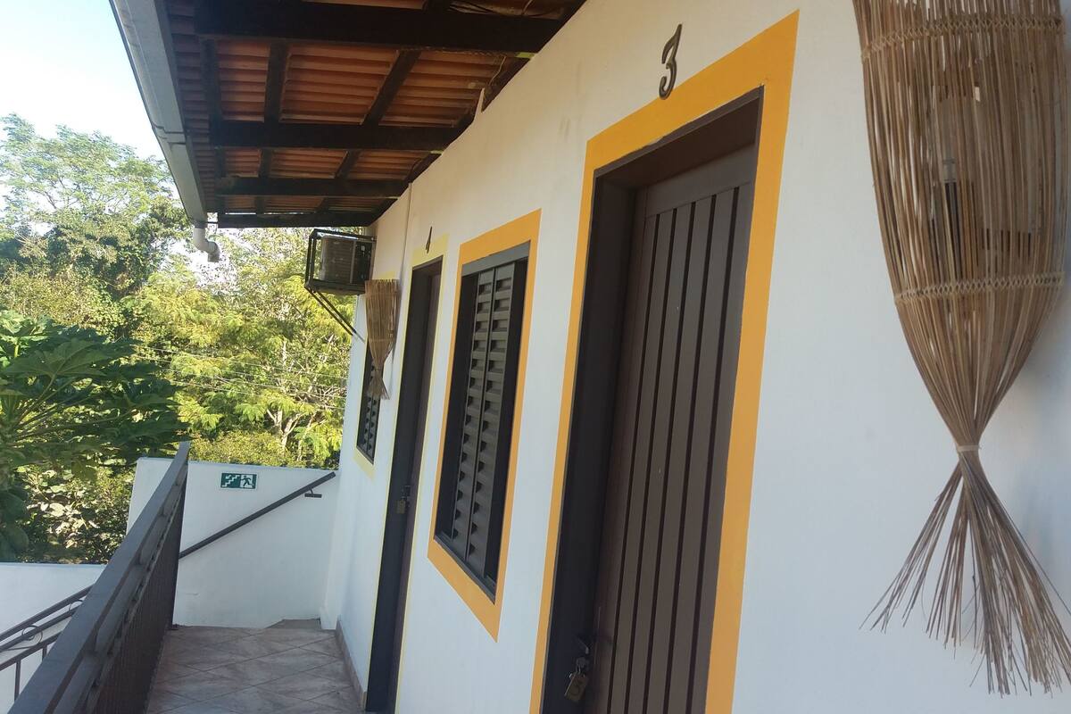 Un bâtiment avec trois portes, un escalier et un balai suspendu.
