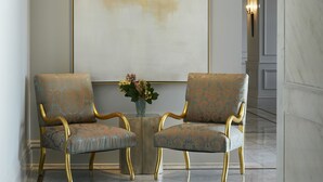 A lobby with two armchairs, a marble floor, and a large abstract painting on the wall. - John Hand Club Hotel (Birmingham)