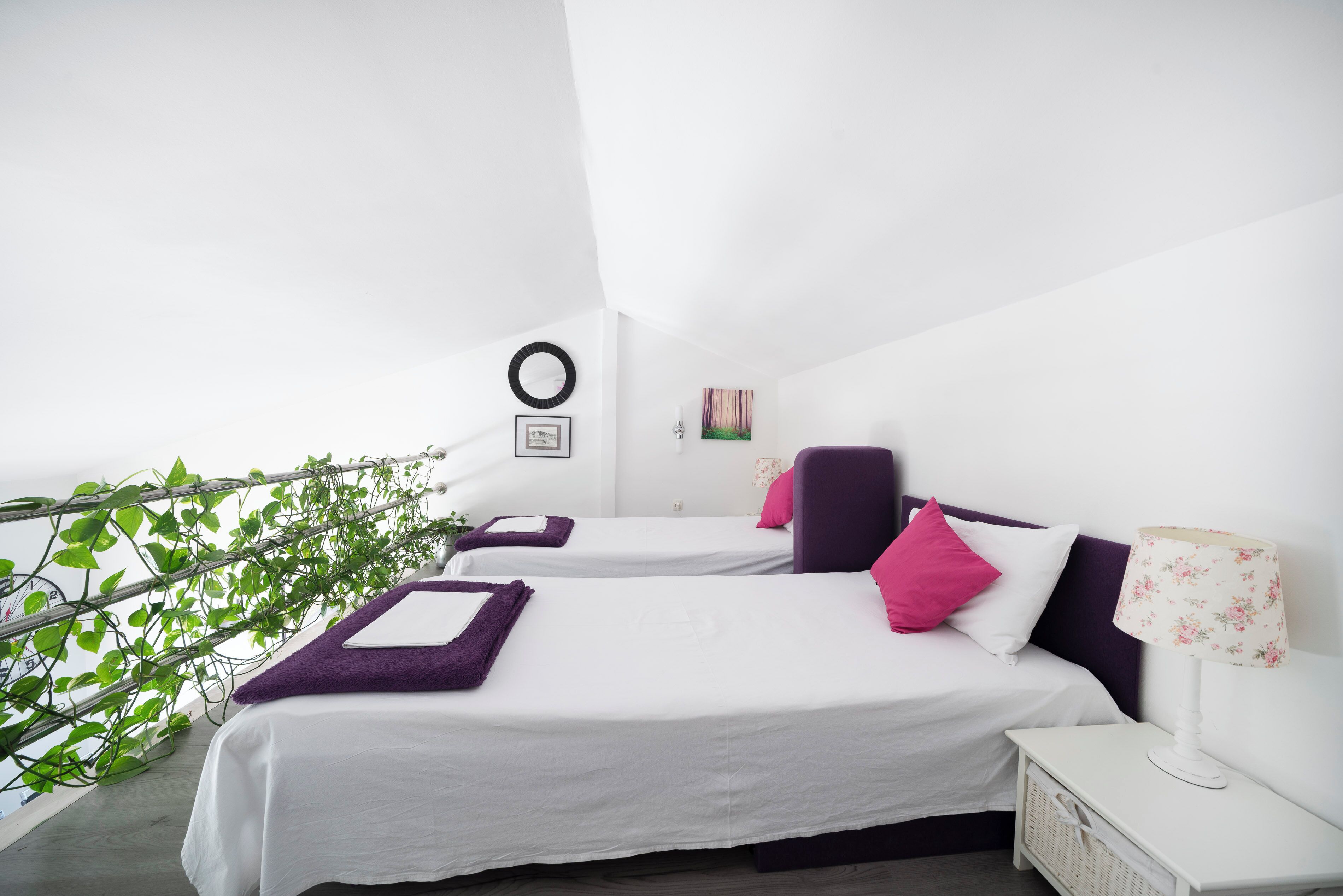 A bedroom with two beds, a small table, and a chair.