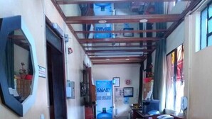A reception area with a counter, a mirror, and a poster advertising a health product. - Hotel Regina (Porto Velho)