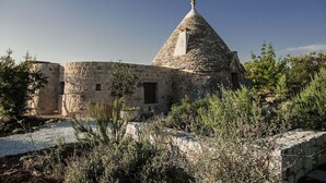 Un edificio de piedra con techo cónico y una pequeña ventana.