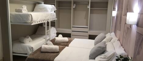 Tabla de planchar con plancha, internet y ropa de cama