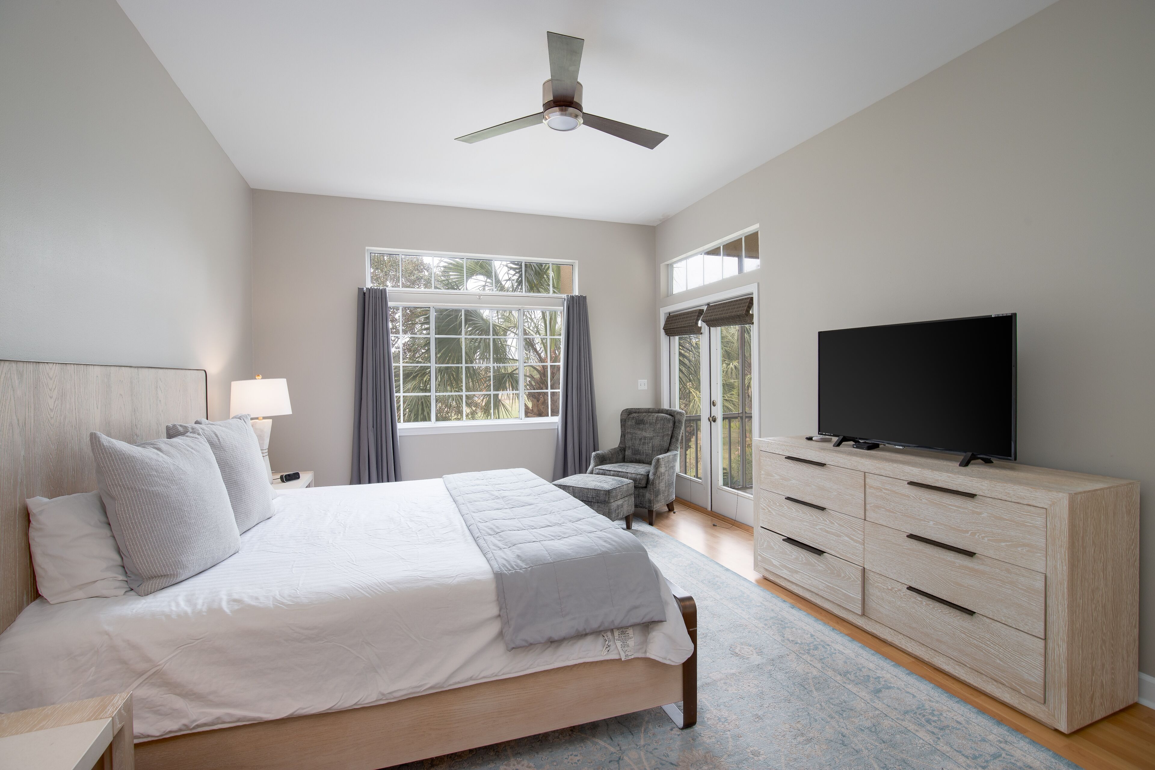 A bedroom with a bed, a TV, a desk, and a chair.