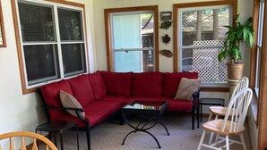 A cozy living room with a red sectional sofa, a wooden dining table, and a ceiling fan. - Convenient, clean and cozy 3 bedroom, 2 bath overlooking idyllic lake whittemore (Spencer)