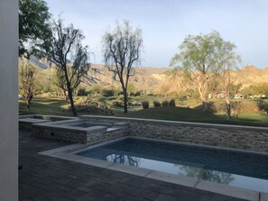 Piscina com degraus de pedra, cercada por um espaço de pátio.