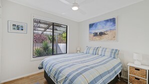 A bedroom with a bed, a window with blinds, a painting, and a nightstand. - Cowes Cottage - short walk to the main street (COWES)