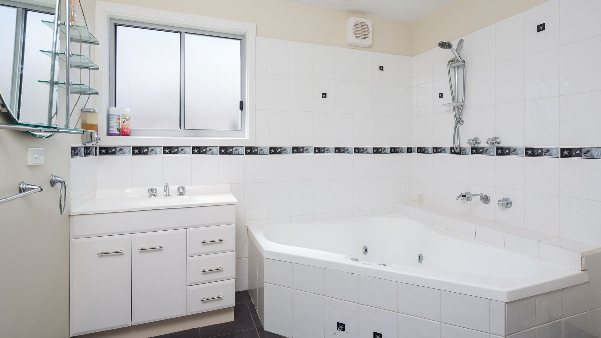 Une salle de bain moderne avec une grande baignoire, un meuble-lavabo avec un miroir et un espace douche.