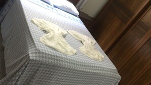 Un lit avec une couvre-lit à motifs, une tête de lit en bois et une fenêtre avec des rideaux.