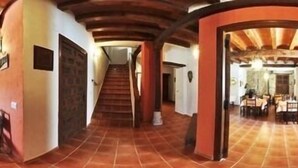 A spacious hallway with a tiled floor, wooden ceiling beams, and a staircase leading to a dining area. - Rural house (full rental) El Empecinado for 23 people (Fuentelviejo)