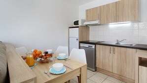 Una cocina compacta con armarios de madera, lavavajillas y microondas.