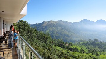 A balcony with a view of a lush valley and mountains.