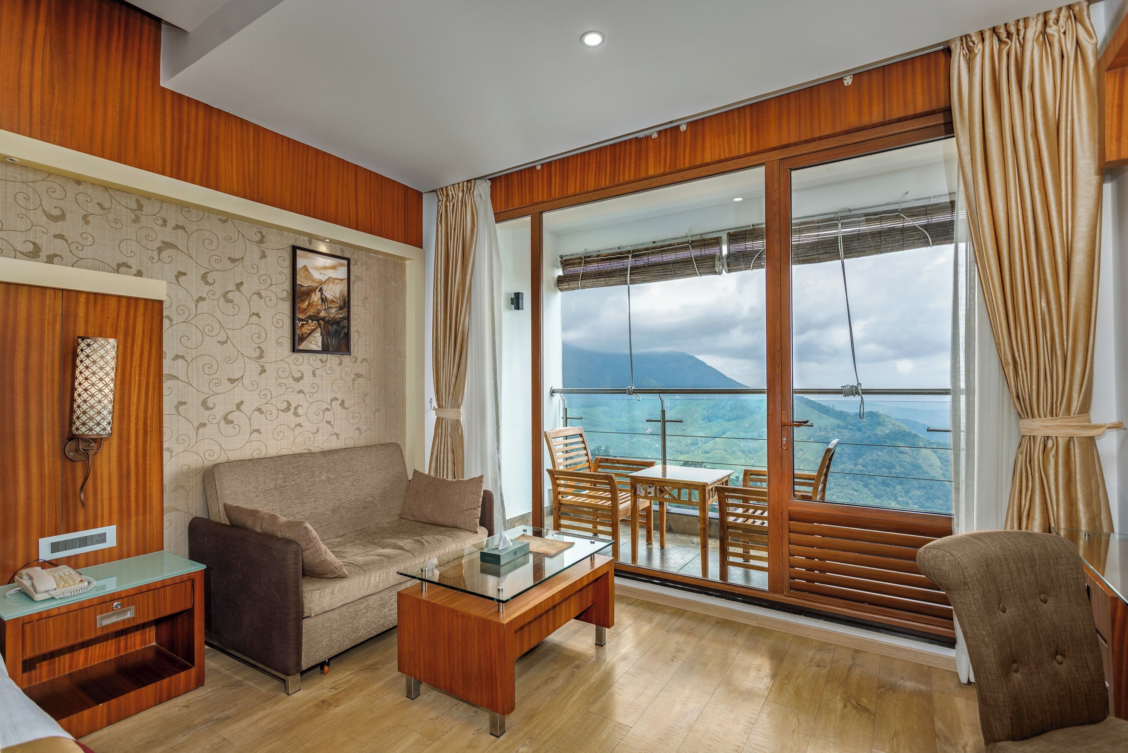A modern living room with a sofa, coffee table, and a view of the ocean through large windows.