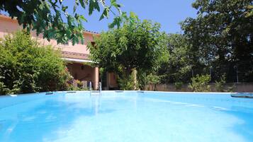 Surrounded by lush greenery, the outdoor pool offers a serene escape.