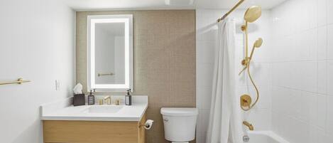 A bathroom with a white sink, mirror, toilet, and bathtub.