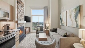 Een moderne woonkamer met een open haard, een bank, een salontafel en een televisie.