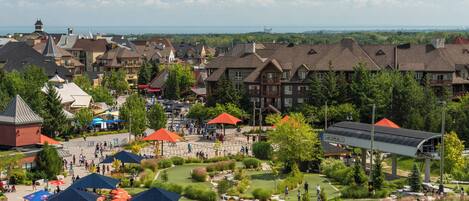 A golf course with a view of surrounding buildings and a distant body of water.