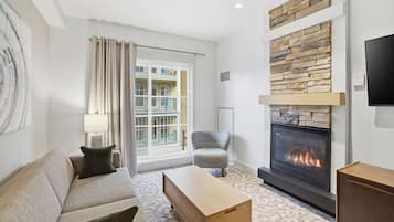 Una sala de estar moderna con chimenea, un sofá, un sillón y una mesa de centro.