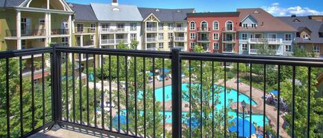 A hotel with multiple balconies overlooking a pool area.