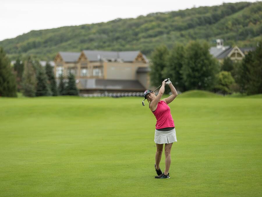 Un campo de golf con una casa al fondo.