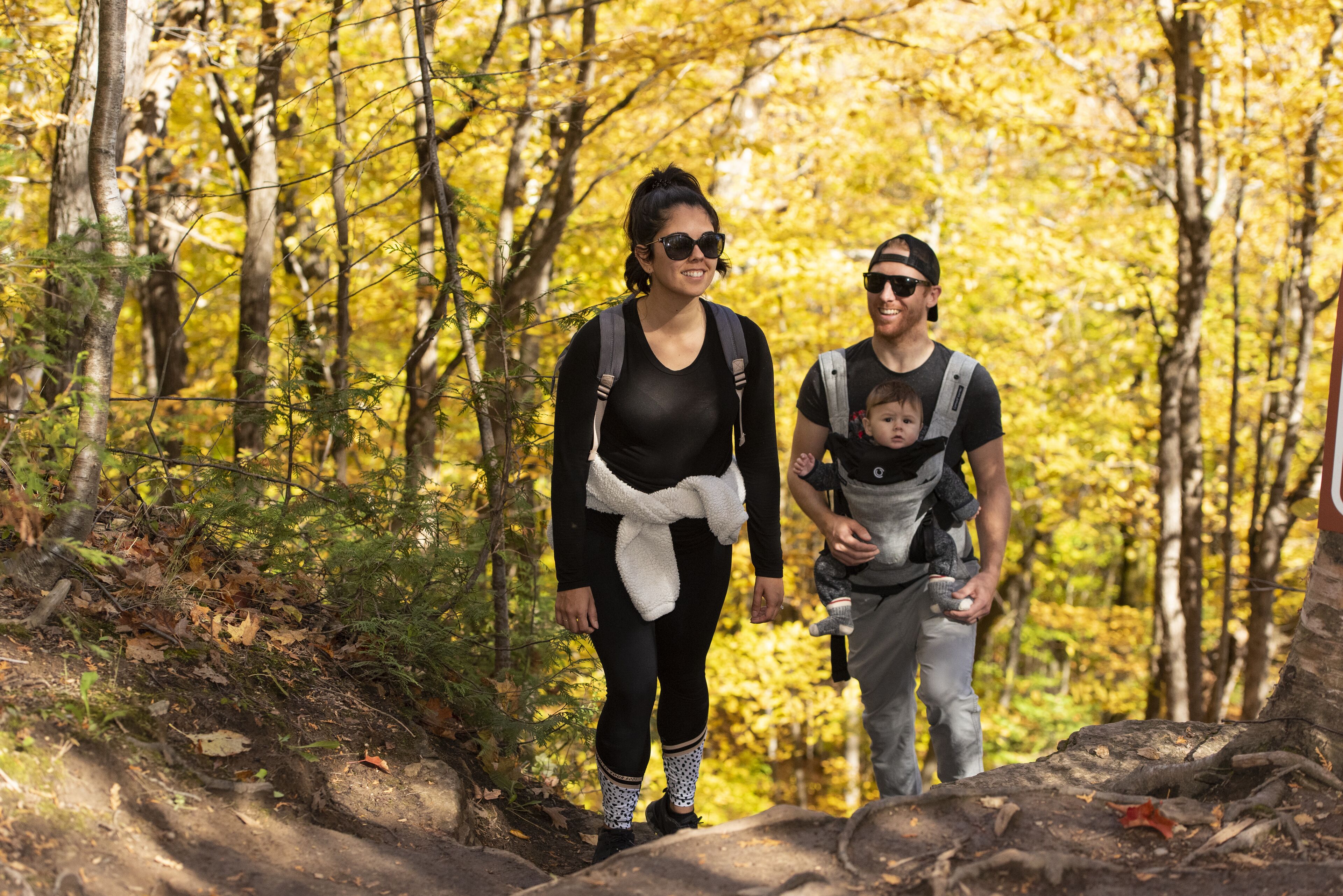 A forested hiking trail with a person and a child.