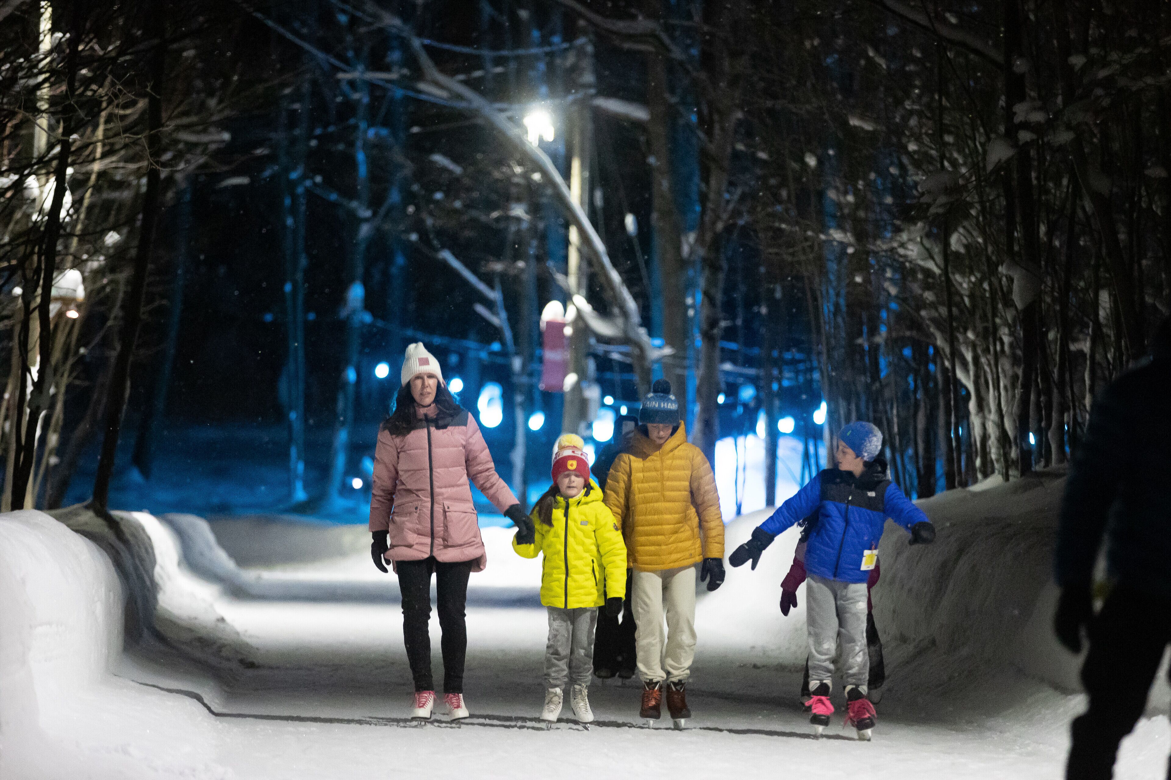 Eine nächtliche Szene, Menschen gehen auf einem verschneiten Weg.