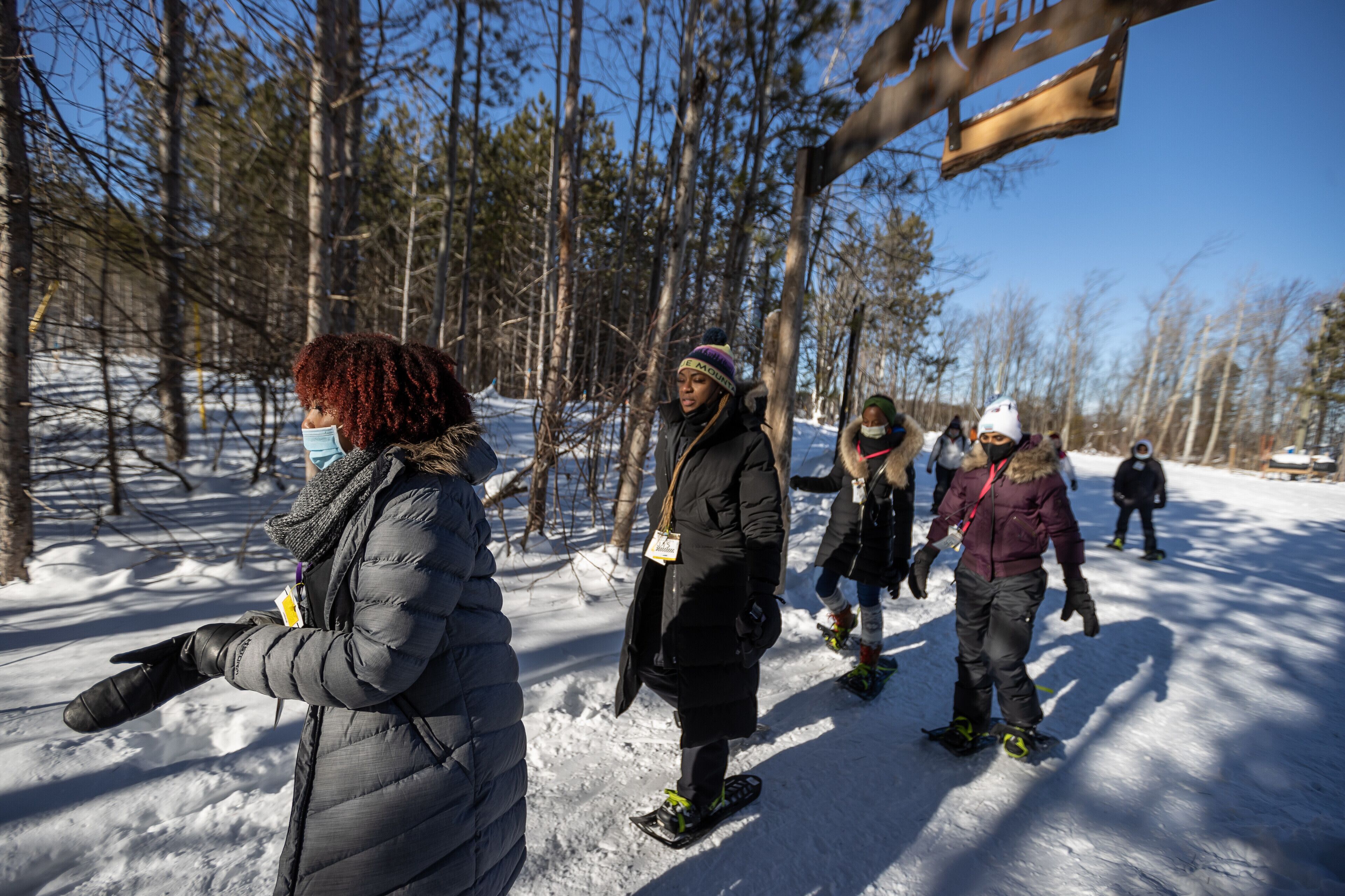 A group of people in a snowy forest setting, likely engaged in winter activities.