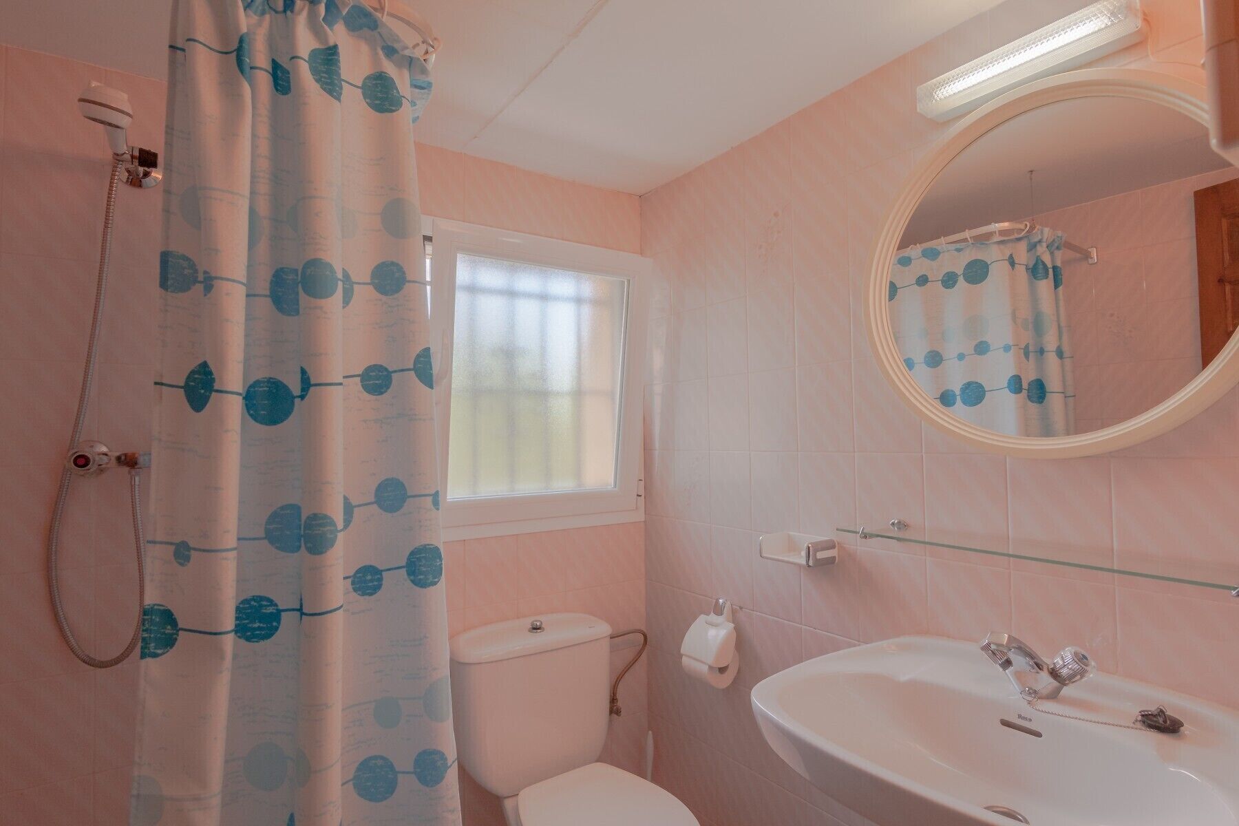 Een badkamer met toilet, wastafel en douche.