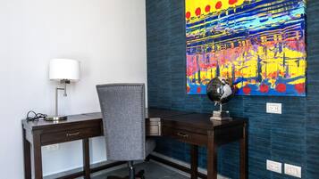 A modern office space with a desk, chair, lamp, and a globe on the desk.