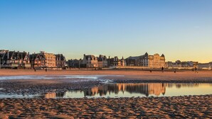 Ein Strand mit Gebäuden im Hintergrund.