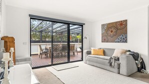 Ein Wohnzimmer mit grauem Sofa, Couchtisch und einem Bild an der Wand.
