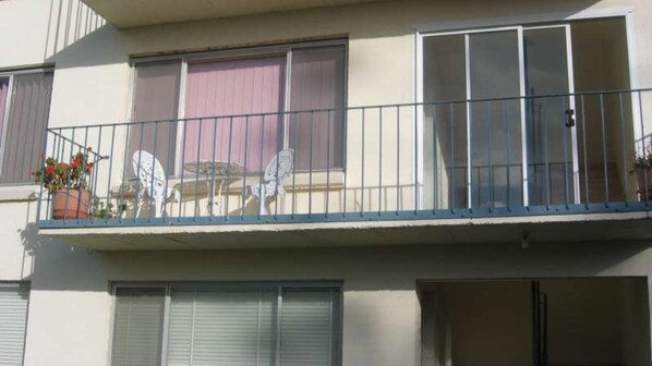 A balcony with a metal railing, a table with chairs, and potted plants. - Warley Hideaway (COWES)