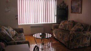 A living room with two patterned sofas, a coffee table, and a radiator. - Warley Hideaway (COWES)