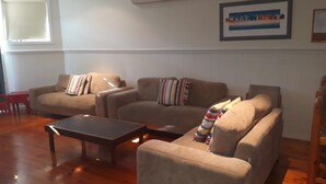 Una sala de estar con dos sofás color beige, una mesa de centro de madera y un cuadro en la pared.