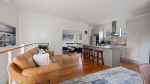 Un appartement moderne comprenant un espace de vie, une cuisine et un coin repas.