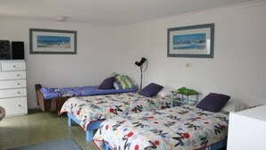 A bedroom with two beds, a dresser, and two framed pictures on the wall. - Salt On Seacombe (VENTNOR)