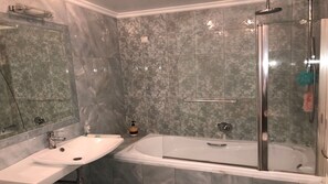 Ein Badezimmer mit einem Waschbecken, einer Badewanne und einer Duschkabine.