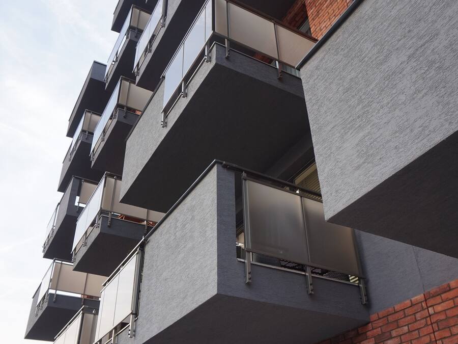 A multi-story building with balconies and large windows.