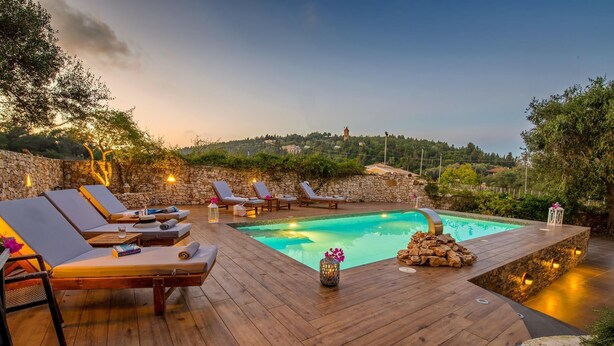 Eine Holzterrasse mit Liegestühlen und einem Swimmingpool.