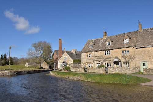Period cottage in idyllic riverside location in prime Cotswolds village